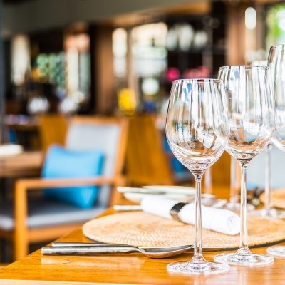 Três copos de vinho transparentes numa mesa de restaurante