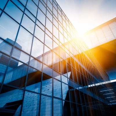 Fachada de edifício moderno com janelas de vidro refletindo o céu