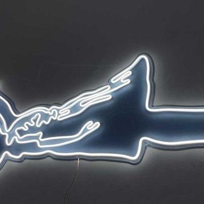 Neon art figura de pessoa deitada segurando balão vermelho em coração com luzes brancas