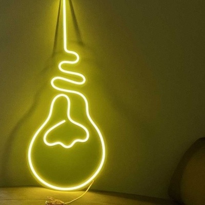 Luz de néon amarela em parede amarela de quarto com sofá castanho e móvel