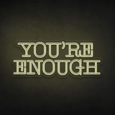 Sinal de néon a dizer YOU'RE ENOUGH em amarelo sobre fundo escuro