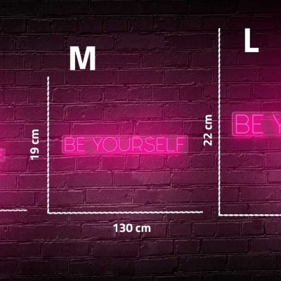 Letreiros de néon rosa BE YOURSELF em parede de tijolos com medidas S, M e L.