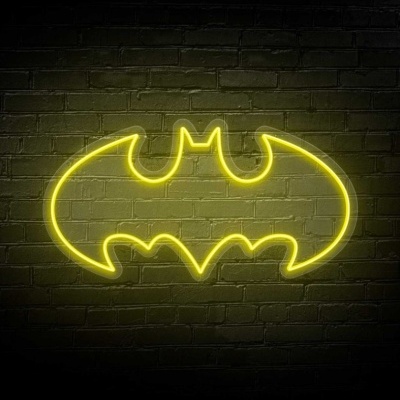 Sinal de neon amarelo com o logotipo do Batman numa parede de tijolos escuros