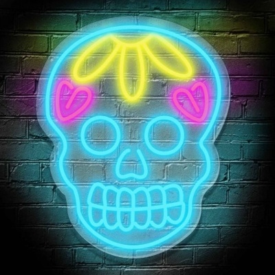 Letreiro de néon em forma de caveira colorida numa parede de tijolos