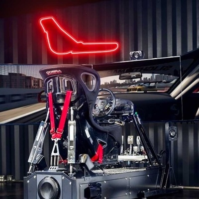 Simulador de condução de automóveis com luz de néon vermelha na forma de avião