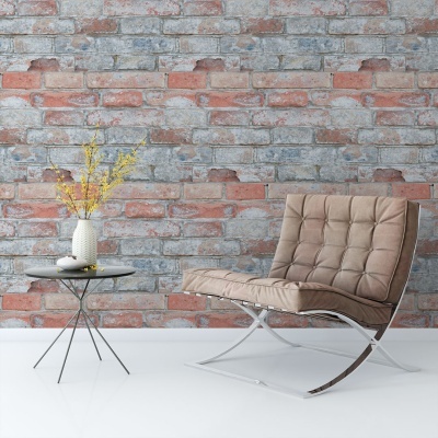 Cadeira castanha acolchoada ao lado de mesa de apoio preta com vaso florido, parede de tijolos