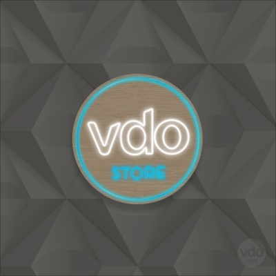 Placa redonda com texto 'vdo STORE' em madeira com luz neon sobre fundo cinza geométrico