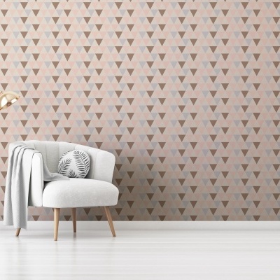 cadeira cinzenta com almofada e manta junto a candeeiro dourado com parede geométrica