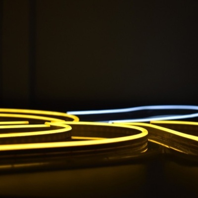 Luzes de néon amarelas e brancas sobre fundo escuro