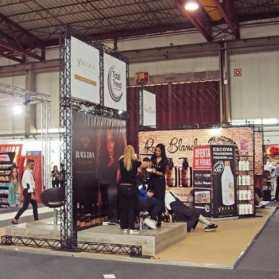 Estande de feira comercial com banners da marca Ybera e pessoas