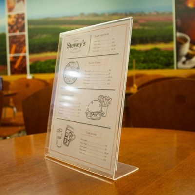 Expositor plástico transparente em forma de L numa mesa de madeira