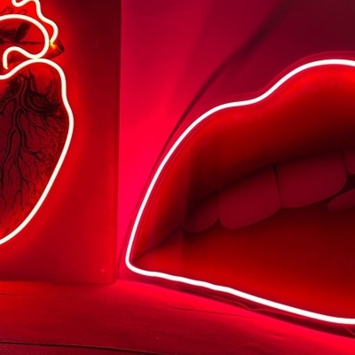 Letreiros de néon em forma de coração humano e lábios vermelhos brilhantes