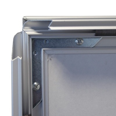 Canto de quadro metálico cinzento com parafusos e superfície branca