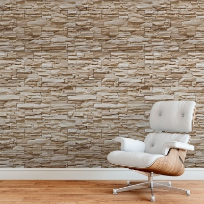 Poltrona branca estofada com estrutura de madeira clara junto a parede de pedra decorativa