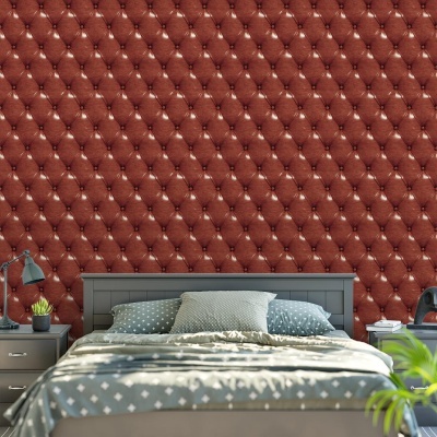 Papel de parede vermelho acolchoado num quarto com cama cinza e decoração azul e cinza