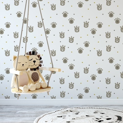 Cadeira de baloiço infantil com almofadas de gato e leão e padrão de patas na parede