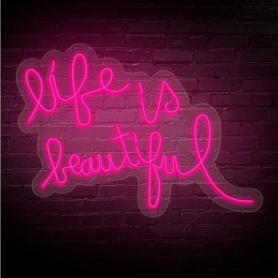 Letreiro em néon rosa com frase 'life is beautiful' numa parede de tijolos