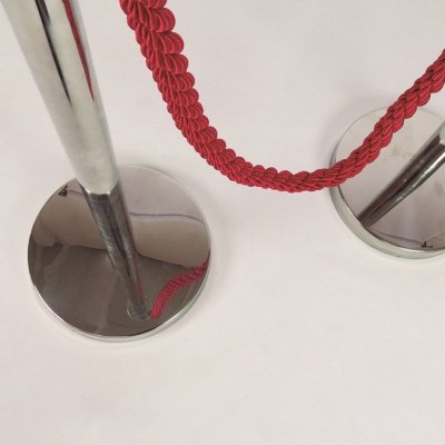 Cordão vermelho entre colunas metálicas prateadas.