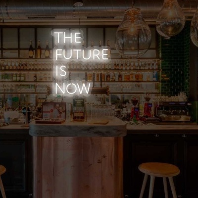 Balcão de bar com bancos e texto em néon THE FUTURE IS NOW