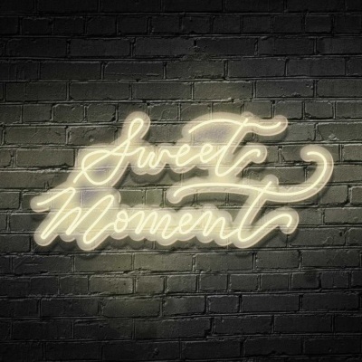 Letreiro em luz de néon branca com a frase 'Sweet Moment' em letra cursiva.