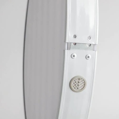 Detalhe de moldura oval branca com botão circular e detalhes metálicos