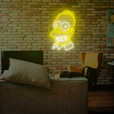 Quarto com parede de tijolos, cama cinzenta, cadeira amarela, secretária, mapa da África e neon Homer Simpson