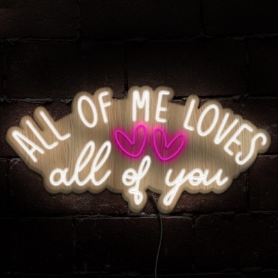 Placa de luz neon com a frase 'ALL OF ME LOVES all of you' e dois corações cor-de-rosa