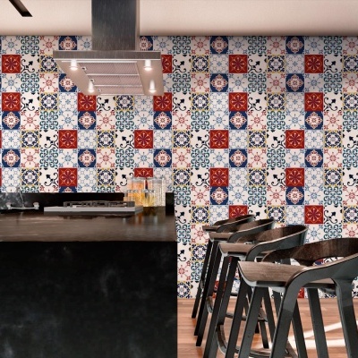 Cozinha moderna com ilha preta e cadeiras altas junto a parede com azulejos coloridos em padrões geométricos