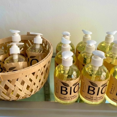 Garrafa de gel de banho BIO amarelo com tampa doseadora branca em cesta e várias ao lado