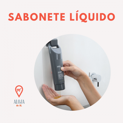 Mãos a usar dispensador de sabonete líquido cinzento na parede