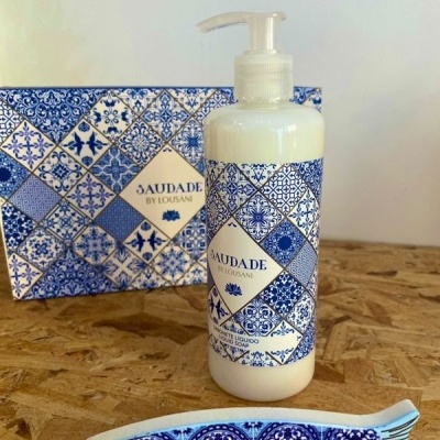 Frasco de líquido com doseador e padrão de azulejos azuis e brancos, caixa com mesmo padrão e figura de peixe decorativa