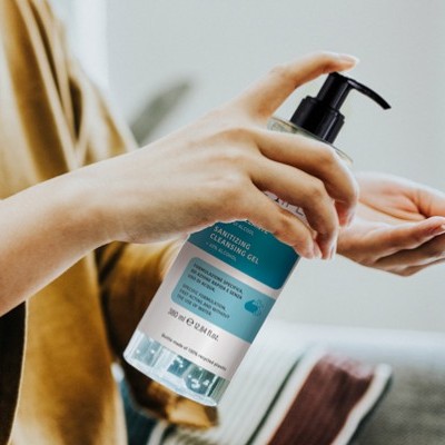 Pessoa a usar gel de limpeza hidratante em frasco com pump