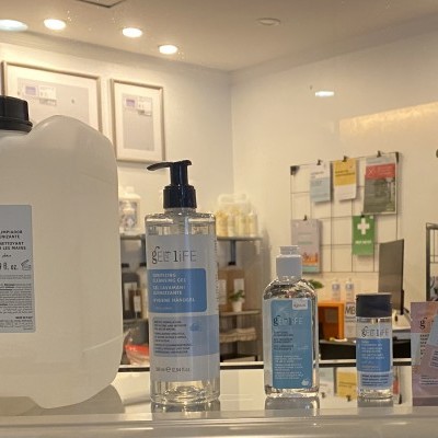 Produtos de higiene BE LIFE expostos numa loja clara com estantes ao fundo e uma planta decorativa.