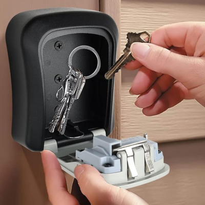 Cofre de chaves preto aberto montado na parede com chaves dentro.