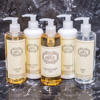 Conjunto de produtos de cuidado pessoal Aroma de Portugal com dispensadores em superfície escura.