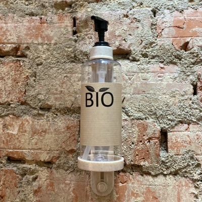 Frasco dispensador transparente com tampa preta e rótulo bege com texto BIO