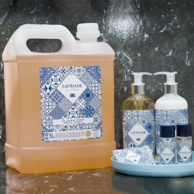 Produtos de higiene pessoal Saudade com rótulos azuis e brancos em recipiente grande e embalagens pequenas sobre uma superfície