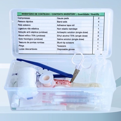 Caixa transparente com material de primeiros socorros e lista de conteúdos em português e inglês