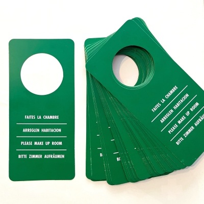 Cartões verdes para pendurar em portas com texto multilingue a pedir limpeza do quarto