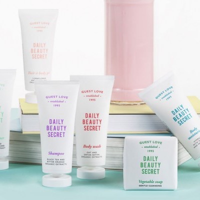 Produtos de beleza 'Daily Beauty Secret' da Guest Love em embalagens brancas com detalhes coloridos sobre livros