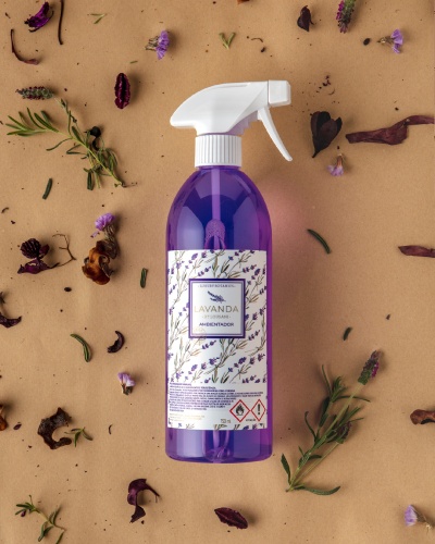 Spray ambientador de lavanda em frasco roxo com tampa branca sobre fundo castanho com flores secas