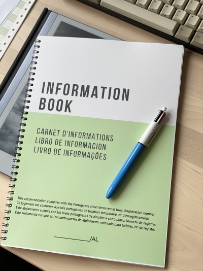 Livro de informação branco e verde com caneta azul e branca sobre secretária