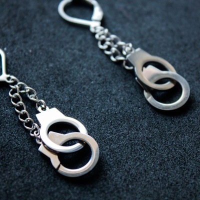 Brincos em metal prateado com anéis entrelaçados e corrente