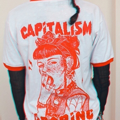 T-shirt branca com estampa vermelha e texto CAPITALISM BORING vista de costas