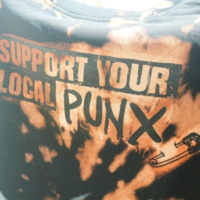 T-shirt tie-dye preta e laranja com texto e desenho estampados