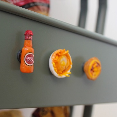 Torneiras de gaveta com forma de cerveja, ovo e pastelaria numa gaveta verde