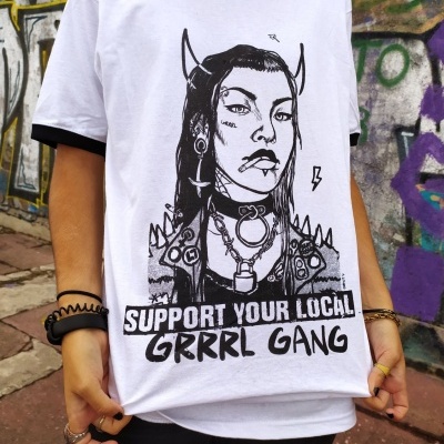 T-shirt branca com estampa punk e texto em fundo urbano com graffiti.