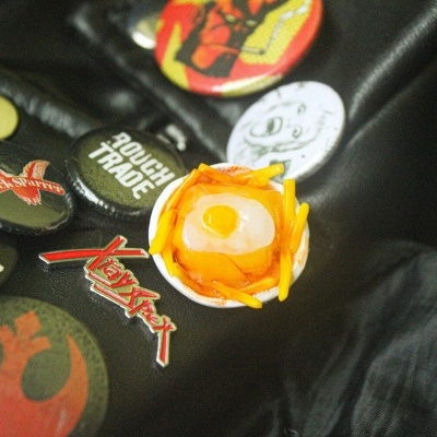 Botões e pins coloridos variados sobre tecido preto