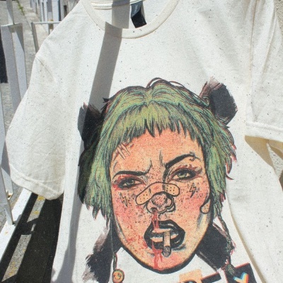 T-shirt branca com estampa colorida de rosto feminino e texto OBEY.