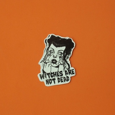 Autocolante preto e branco com rosto e texto sobre fundo laranja